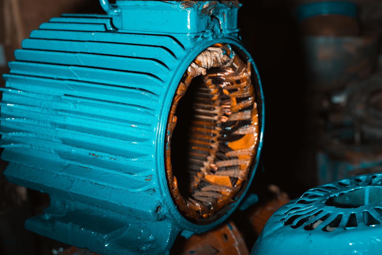 Disassembled electric motor stator and internal components showing salvageable or rebuildable motor value