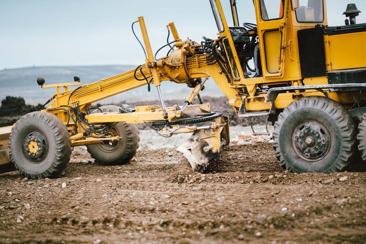 Highway construction site with motor grader and roadbuilding equipment during active development work