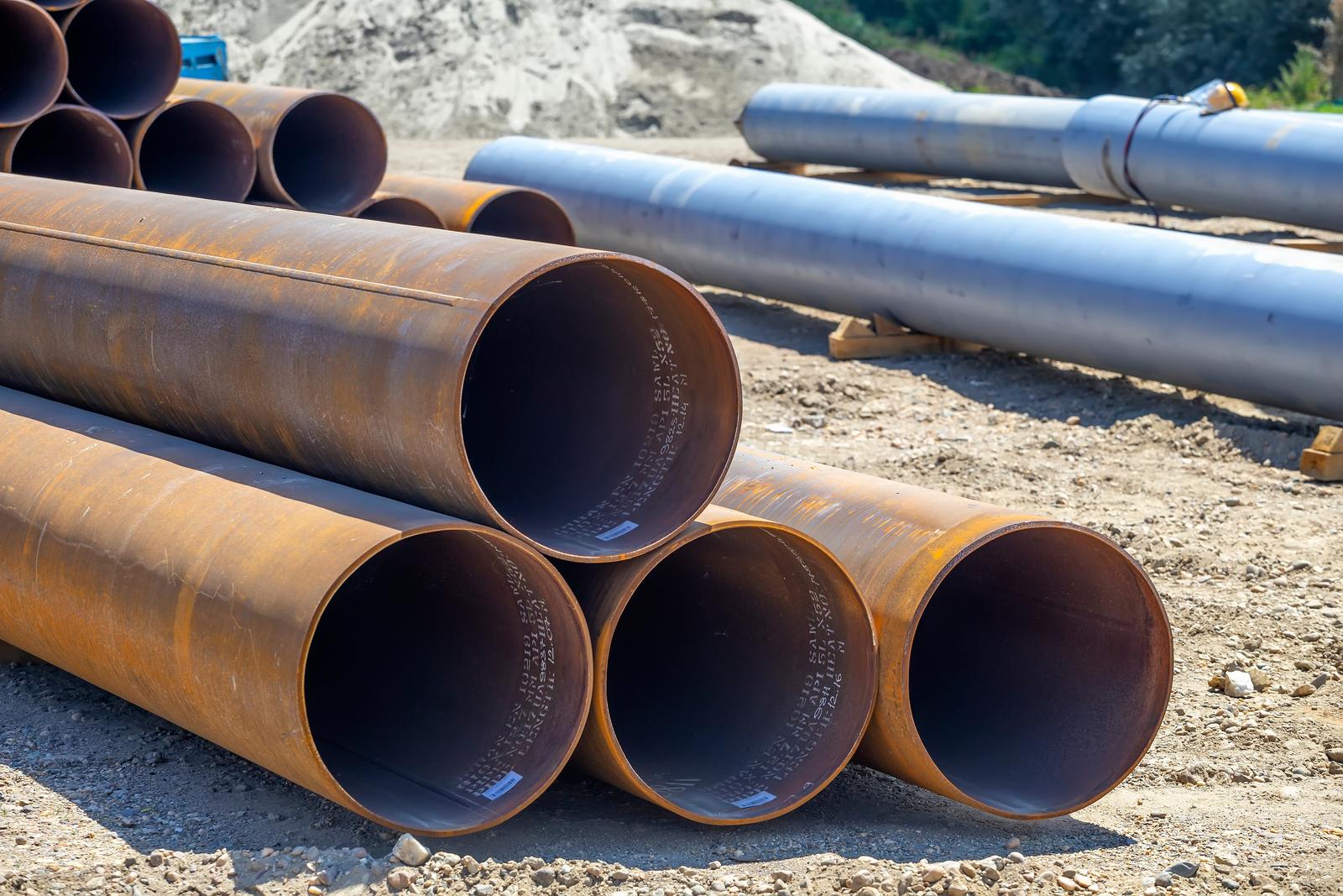 Industrial metal pipes laid on the ground during a construction or utility piping project