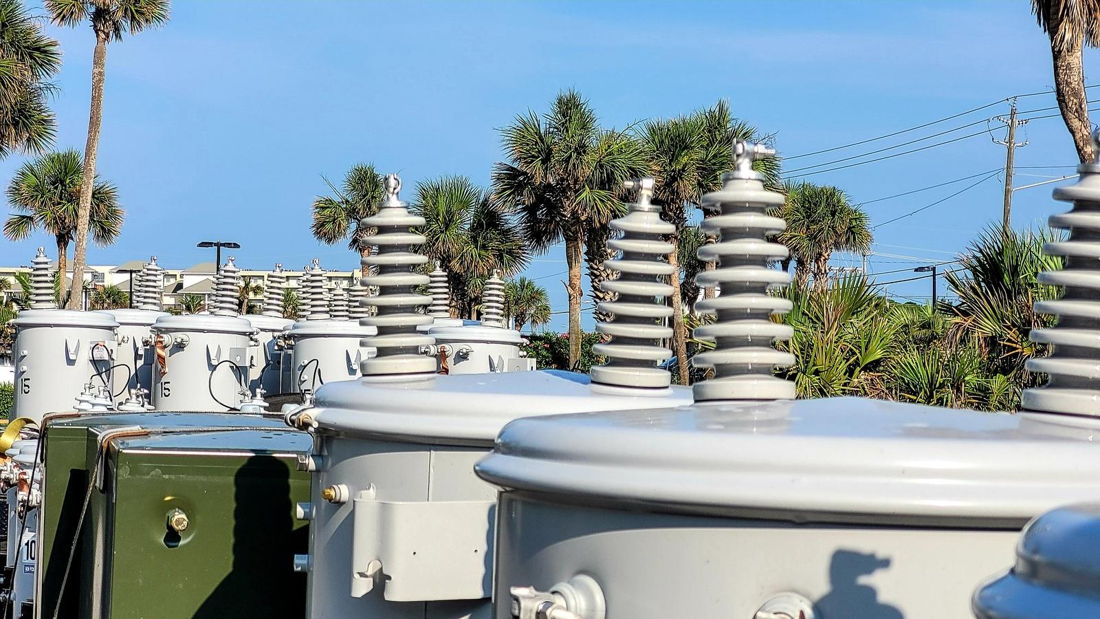 Rows of industrial transformers stored outdoors and available for resale, redeployment, or surplus liquidation