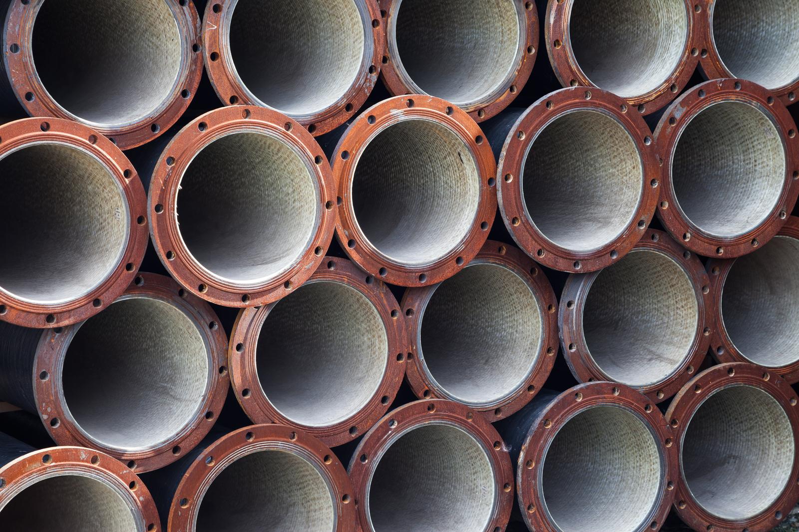 Rusted metal pipes stacked outdoors with resale, reuse, or scrap value