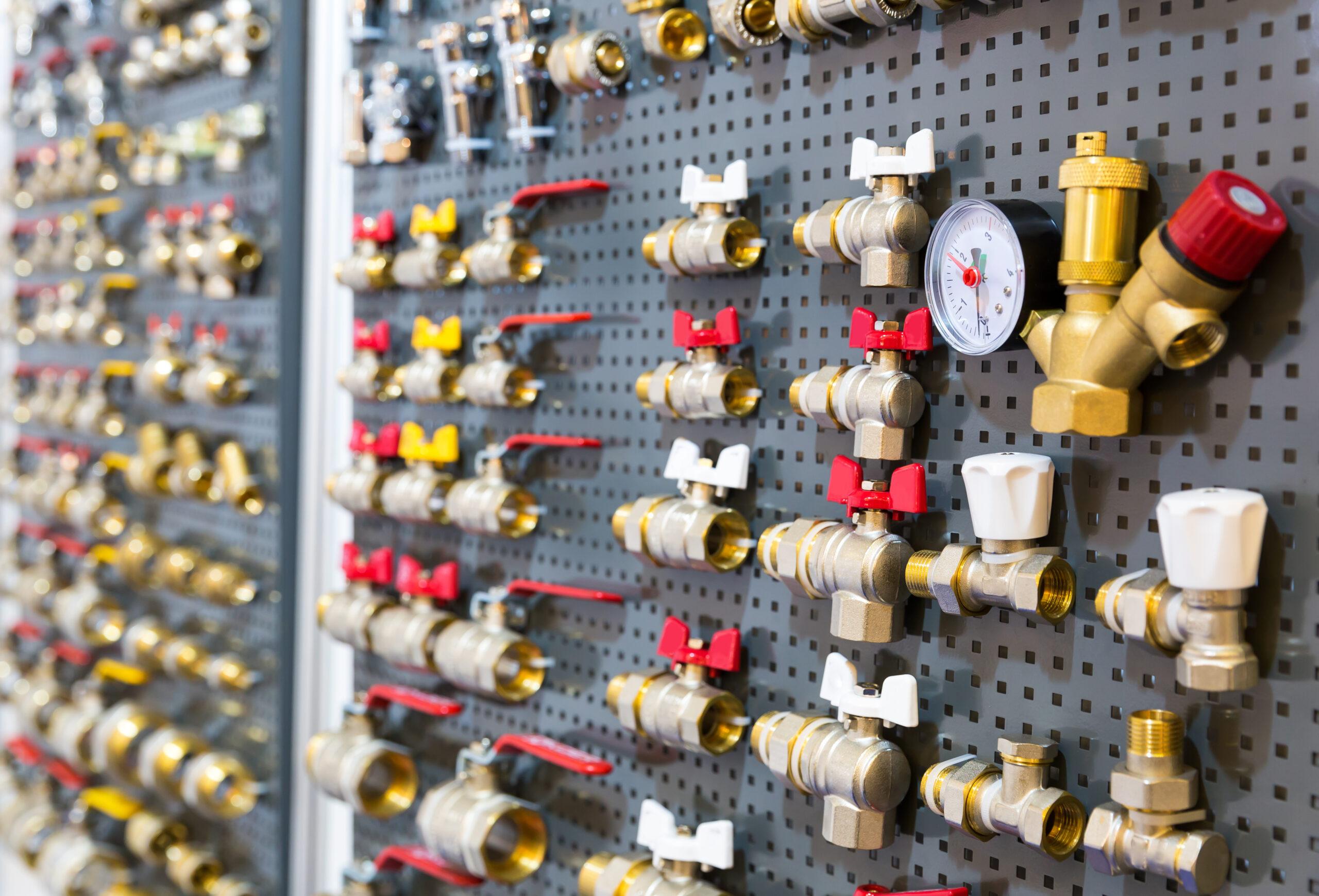 Selection of brass and metal valve-related components representing small valves and organized surplus inventory